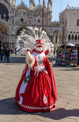 Fototapeta na wymiar Italy, Venice, 2019, carnival, people with beautiful masks walk around Piazza San Marco, in the streets and canals of the city, posing for photographers and tourists, with colorful clothes.