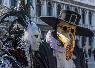Italy, Venice, 2019, carnival, people with beautiful masks walk around Piazza San Marco, in the streets and canals of the city, posing for photographers and tourists, with colorful clothes.