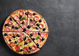 Pizza with Mozzarella cheese, olives, ham, tomato sauce, sausage, pepper, Spices. Italian pizza Italian pizza on wooden table background 