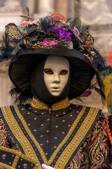 Italy, Venice,  carnival,  2019,  people with beautiful masks walk around Piazza San Marco, in the streets and canals of the city, posing for photographers and tourists, with colorful clothes.