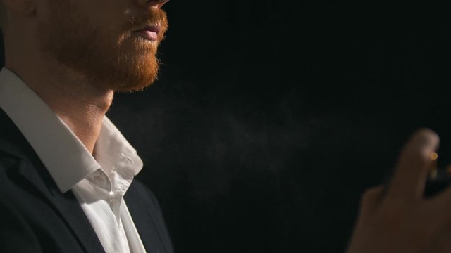 Portrait of young businessman applying cologne