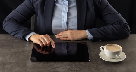 Business woman working on  tablet with dark background and copyspace
