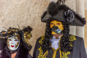 Italy, Venice,  carnival,  2019,  people with beautiful masks walk around Piazza San Marco, in the streets and canals of the city, posing for photographers and tourists, with colorful clothes.