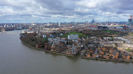 Fototapeta premium Aerial bird's eye view photo taken by drone of Canary Wharf skyline as seen from river Thames with beautiful cloudy sky, Isle of Dogs, London, United Kingdom