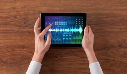 Hand touching tablet with waveforms and sound design concept

