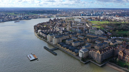 Fototapeta premium Aerial bird's eye view photo taken by drone of Canary Wharf skyline as seen from river Thames with beautiful cloudy sky, Isle of Dogs, London, United Kingdom