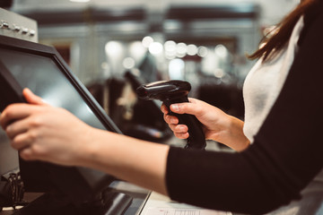 Young woman hand doing process payment on a touchscreen cash register, finance concept (color toned...