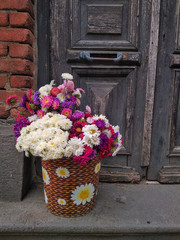 Home flowers in a basket on the porch of the house. Georgian courtyard. Background.