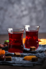 Fruit tea in turkish glasses and oriental sweets. Close-up view, low key