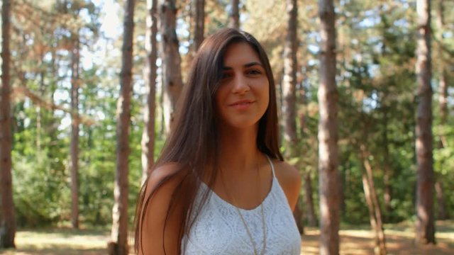 Portrait of beautiful brunette girl flirting with the camera in the park, 4k slow motion