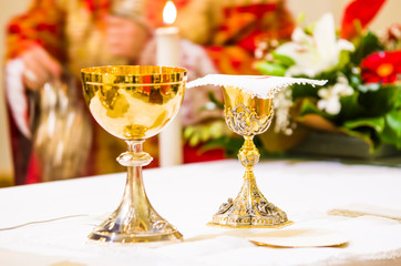 cup with wine and ciborium with host on the altar of the holy mass