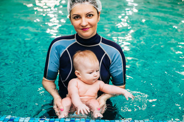 Little boy learning to swim in a swimming pool