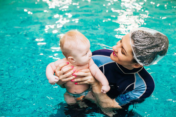 Little boy learning to swim in a swimming pool