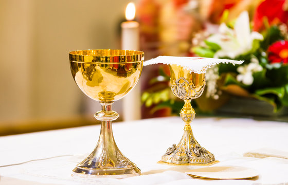 cup with wine and ciborium with host on the altar of the holy mass