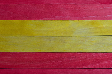 Beautiful texture of natural wood slats of red and yellow colors. Spanish flag. Natural and aged appearance.