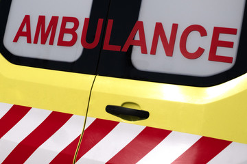 Obraz premium Ambulance. Red inscription on a yellow car. Emergency. Concept for design on the theme of health and helping sick people. Close-up.