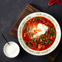 Traditional  ukrainian russian traditional beet red soup - borscht with sour cream on black stone background. Top view.