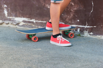 The guy in the red sneakers is on a skateboard. Extreme sport. Skateboarding in the city.