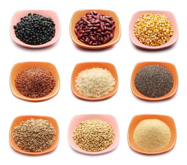 Black and red beans, corn kernels for popcorn, red wild and integral long rice, chia, spelt and wheat grains, amaranth seeds in porcelain bowl isolated on white background, with clipping path 