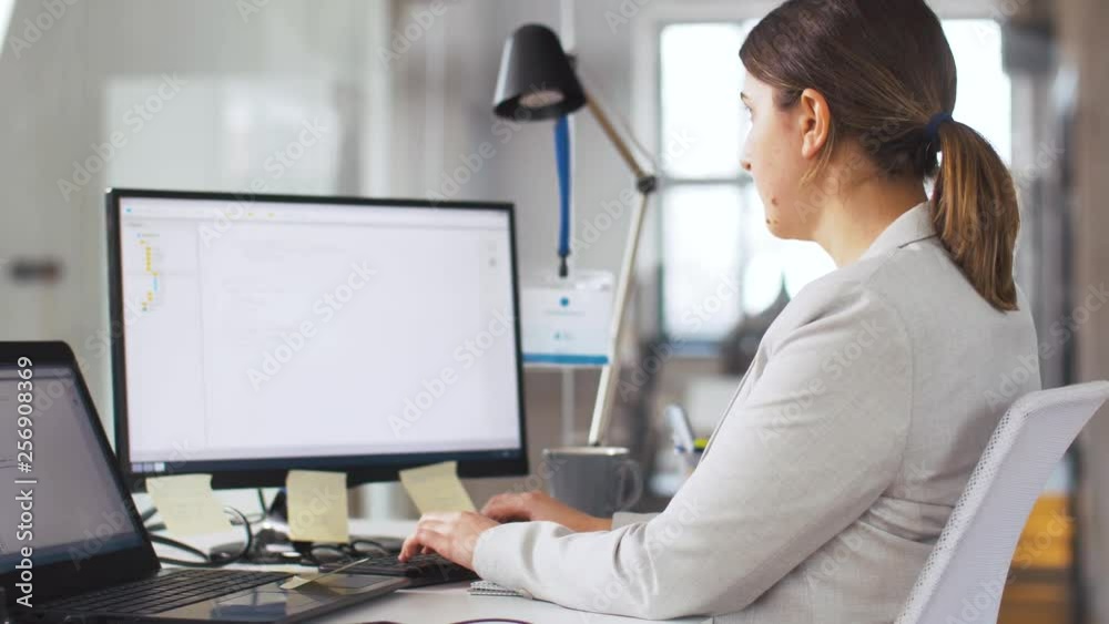Wall mural business, programming and technology concept - female programmer with computer working at office