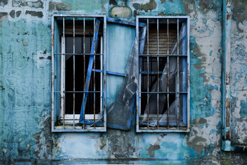 Obraz premium old broken windows on a cracked blue wall