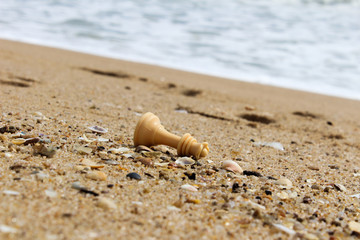 Chess piece in the beach sand.