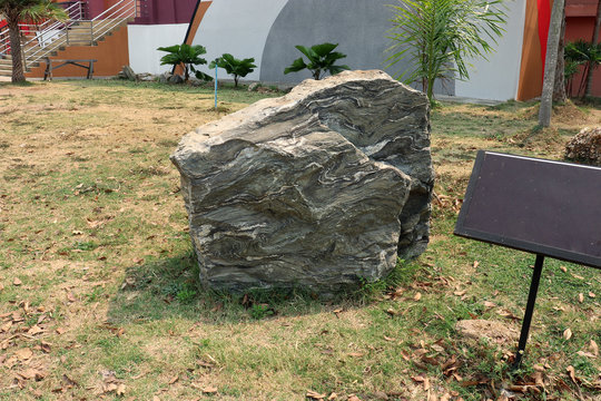 Folded layers of calc-silicate rock (one type of metamorphic rock) from a mountain, Thailand on ground field.