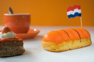 cup of coffee, orange cake and eclaire for typical Dutch event Koningsdag, Kings day