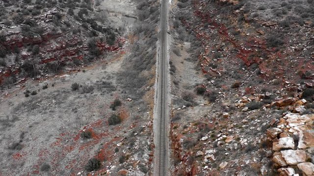 Railroad tracks through rocky mountain landscape aerial drone video 4k