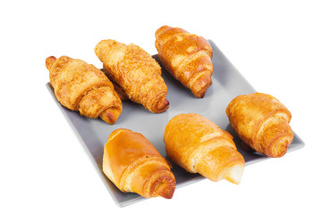 Group of six croissants on gray square shaped plate