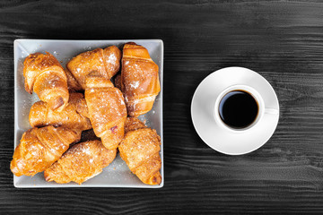 Breakfast flatlay, croissants and coffee on black wooden background