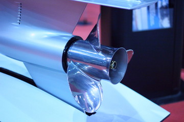 Close up stainless steel motor boat propeller on gear drive shaft of outboard motor - rear side...