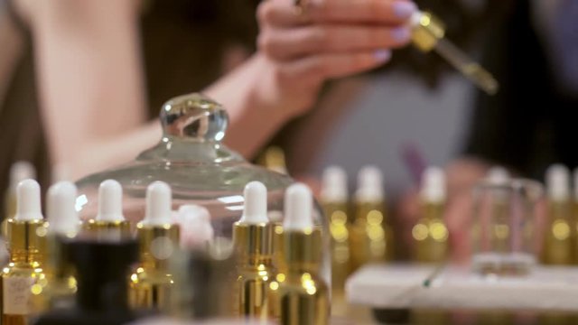 Close up of woman dripping from pipette into alcohol mixture