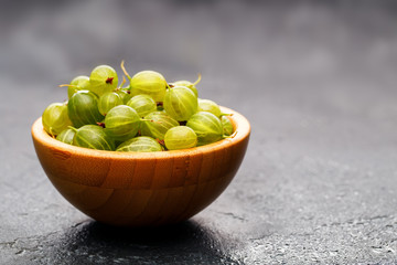 Image of gooseberry berries in wooden cup.