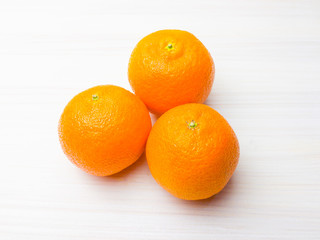 Three tangerine (mandarins)  on a white wooden background