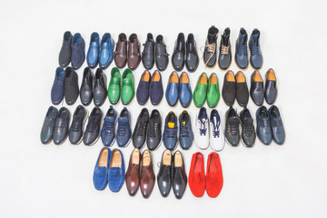 Multicolored men's shoes on a white background. A lot of men's shoes in a row. Types of male shoes. Boots, sneakers and shoes