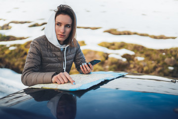 girl hold in hand mobile phone and looking on map, hipster enjoy winter nature, relax tourist travels by auto car, people plan trip in snow mountain, journey landscape trip, lifestyle holiday concept