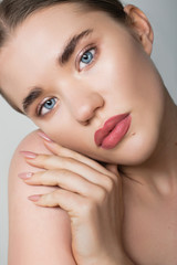 Naklejka premium Closeup portrait of a girl with blue eyes and perfect skin. Facial skin care. Beauty portrait