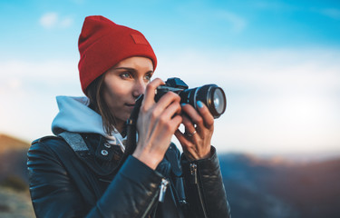 hipster tourist girl hold in hands take photography click on modern photo camera, photographer look...