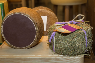 Cheese with Rind Covered with Hay on a Wooden Table