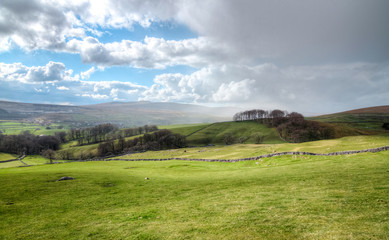 Rain clouds move in over farmland in the Peak District, England.