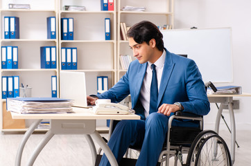 Male employee in wheelchair working at the office