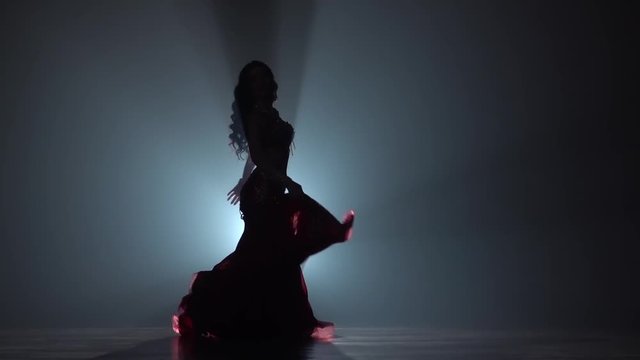 Woman dancing in dress on black smoke background. Sihouette. Slow motion