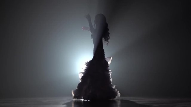 Girl belly dancer arabian in exotic white dress. Smoke background. Slow motion.Sihouette