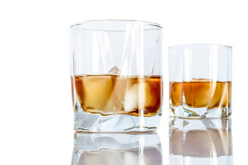 Whiskey with ice close-up in a glass isolated on a white background