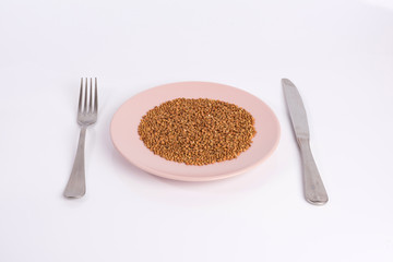 buckwheat groats on a plate isolated on white background