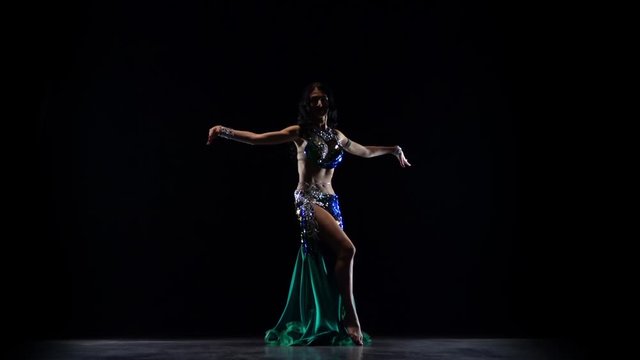 Woman belly dancer arabian in exotic dress dancing . Black background. Slow motion