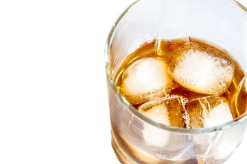 Whiskey with ice close-up in a glass isolated on a white background