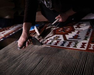 Weaving carpet with traditional techniques on a loom. Wool yarns used as a warp and weft is crucial for this art.Turkey