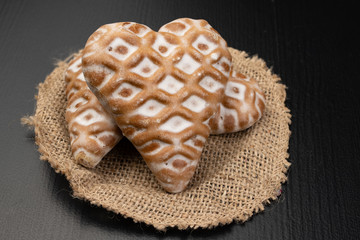 Gingerbread hearts on a wooden kitchen table. Tasty iced cookies.